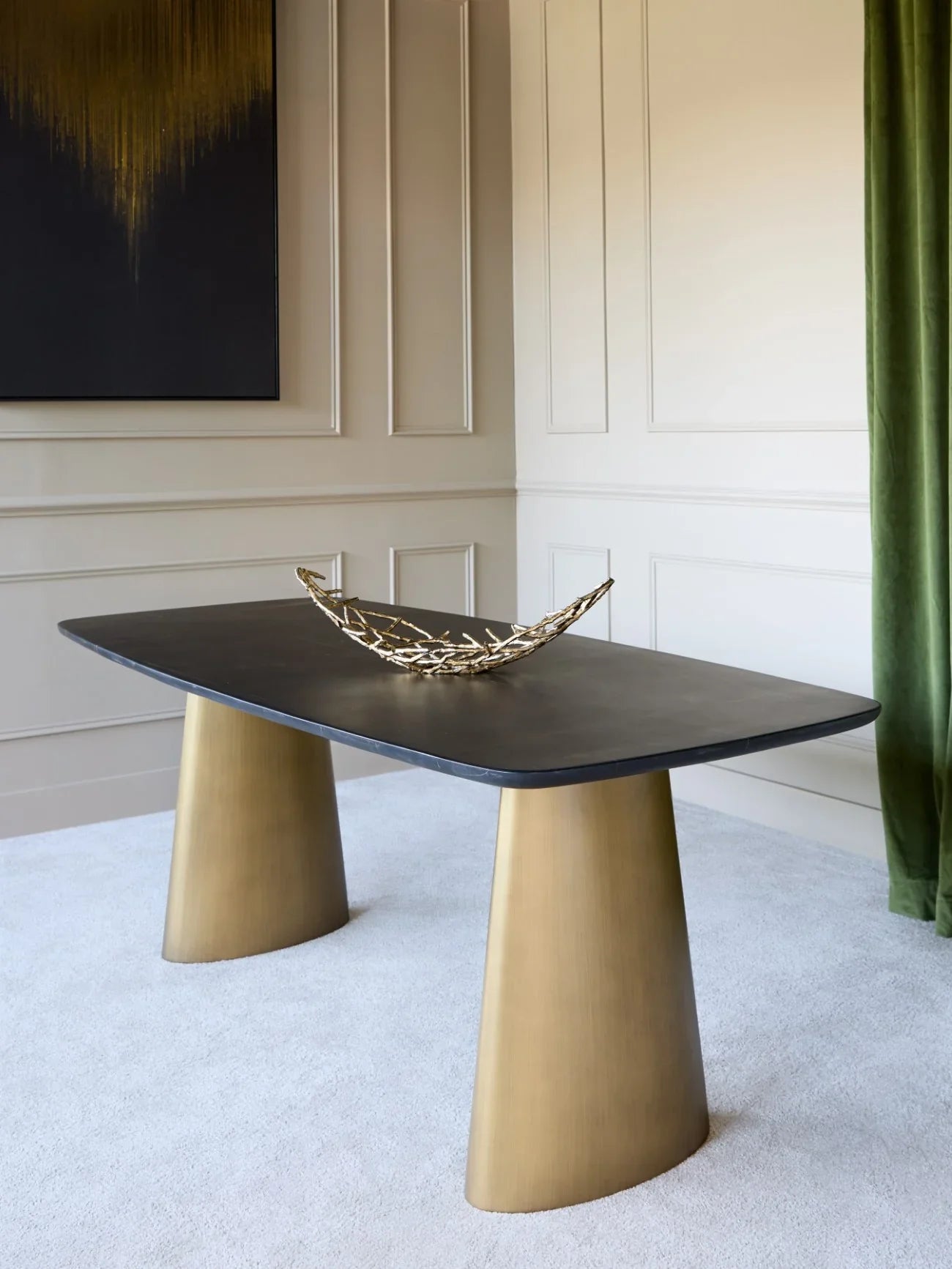 Black marble dining table with brass legs in elegant room setting.