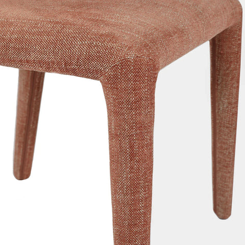 Brown upholstered chair leg with textured fabric detail.