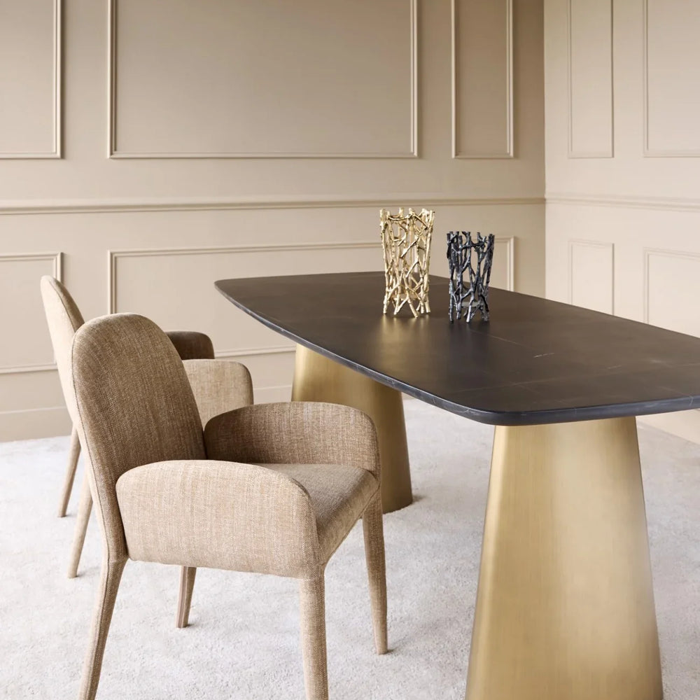 Wheat-toned upholstered chair beside a modern dining table in an elegant room.