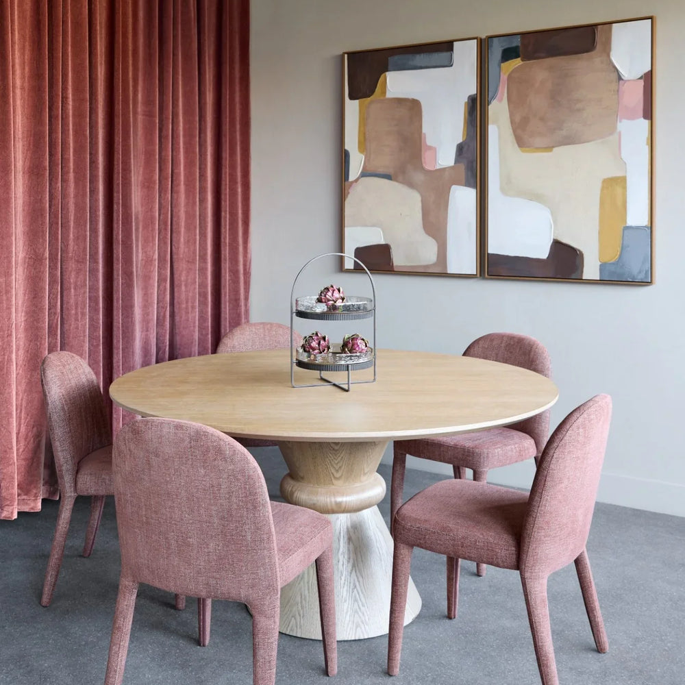 Dining chairs in a modern room with abstract art and pink curtains.