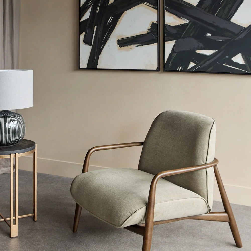 Green fabric chair with wooden arms in modern living room setting.