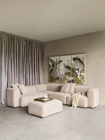 Natural beige sectional sofa with ottoman in a modern living room setting.