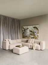 Natural beige sectional sofa with ottoman in a modern living room setting.