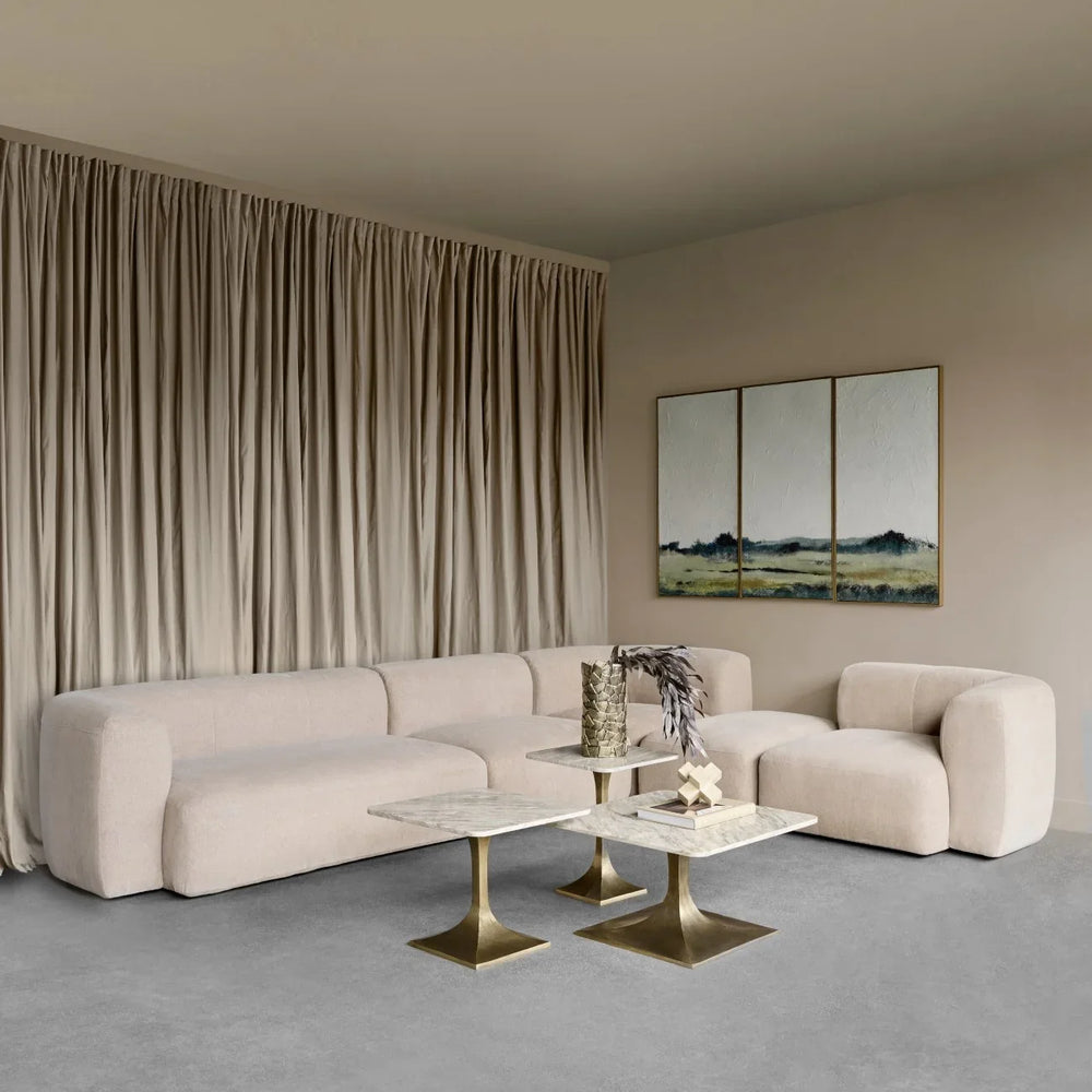 Beige sectional sofa in elegant living room with marble tables.