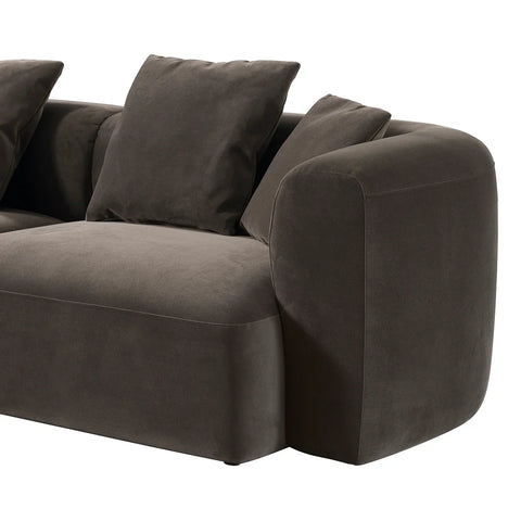 Brown velvet sofa with plush cushions and rounded armrest design.