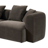 Brown velvet sofa with plush cushions and rounded armrest design.