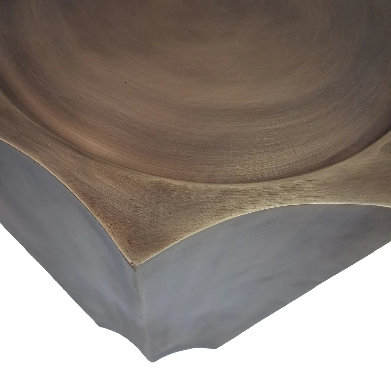 Antique brass plinth corner with smooth, curved edges and subtle texture.