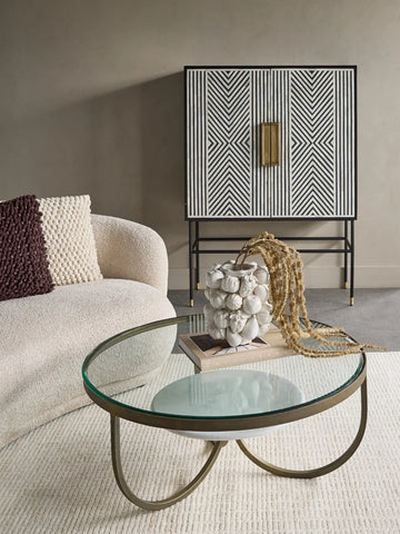 Black and white patterned cabinet in a modern living room with a glass coffee table.