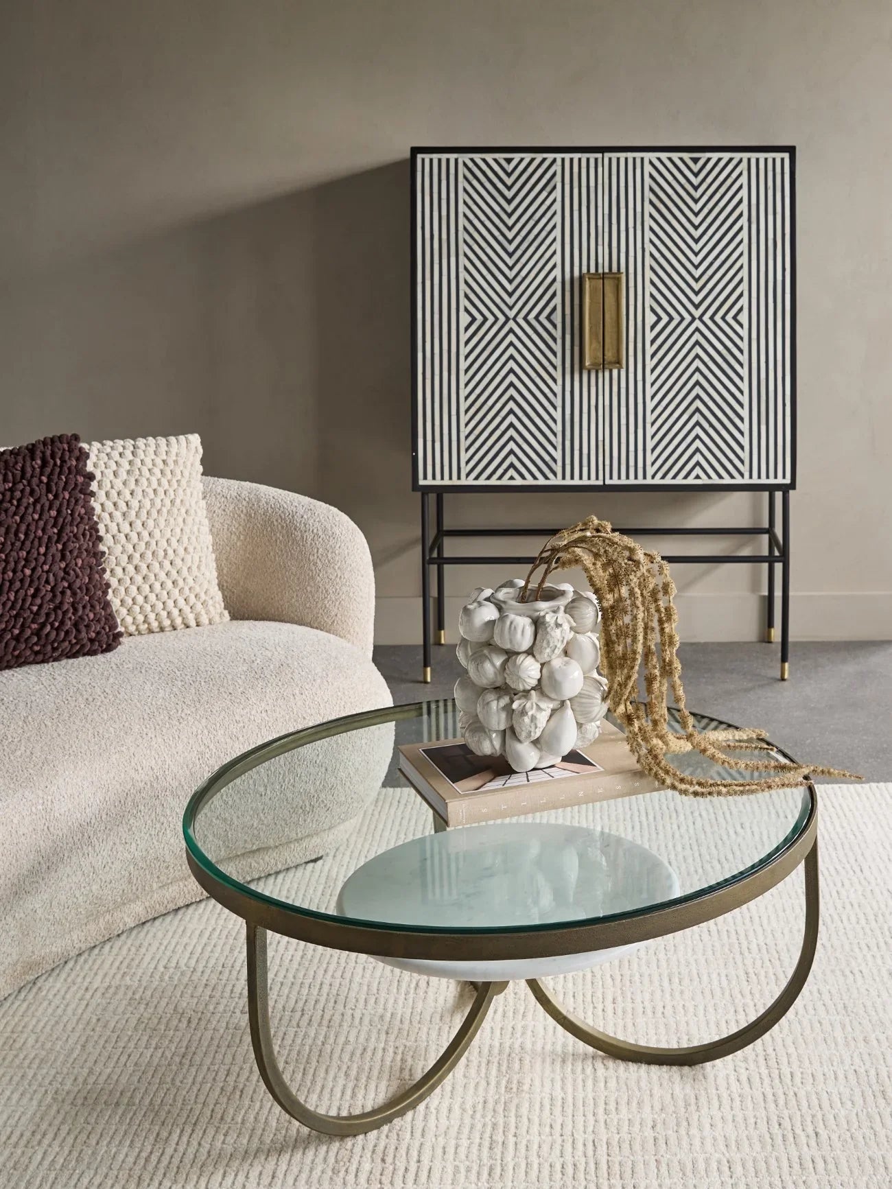 Black and white patterned cabinet in a modern living room with a glass coffee table.