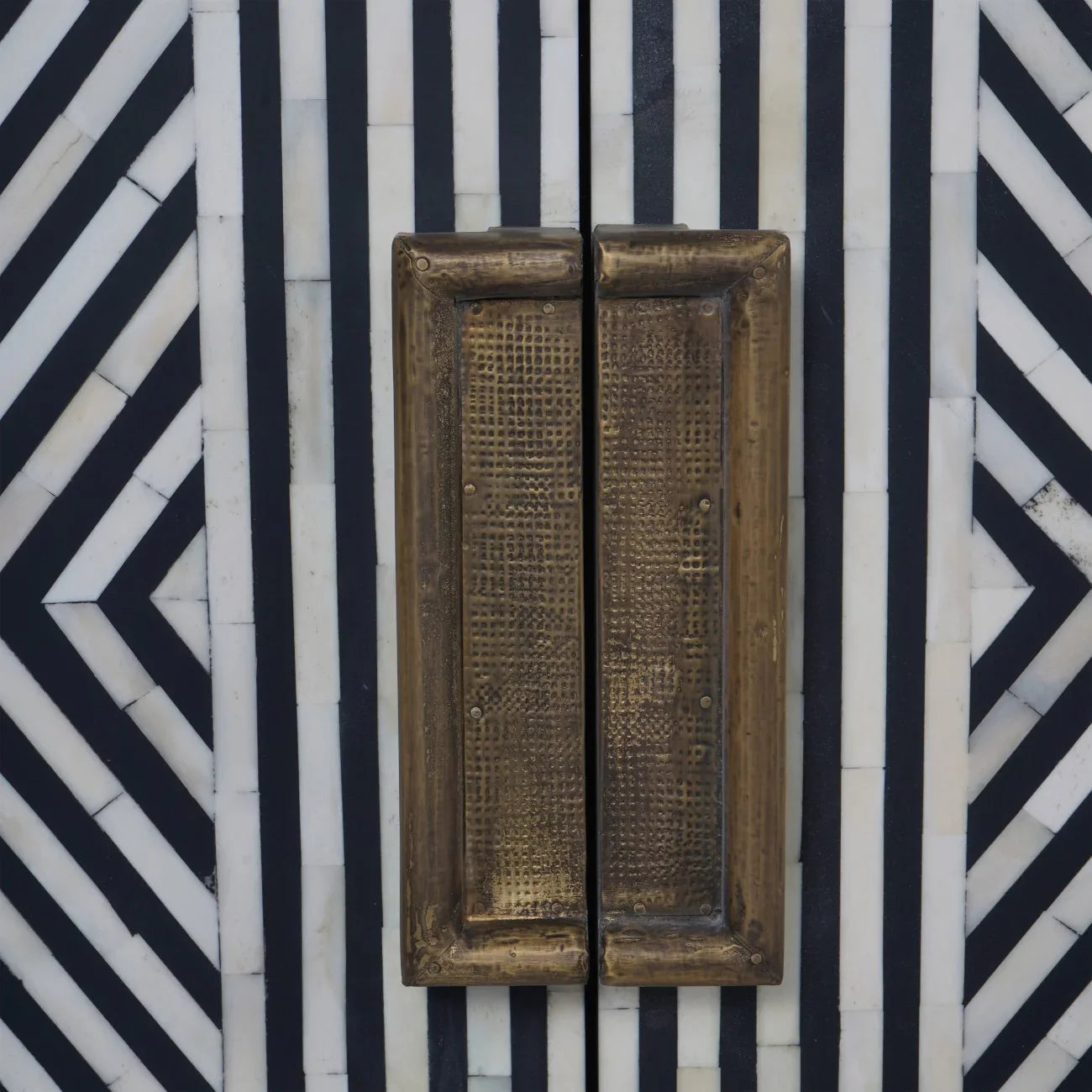 Black and white geometric pattern with textured brass handles