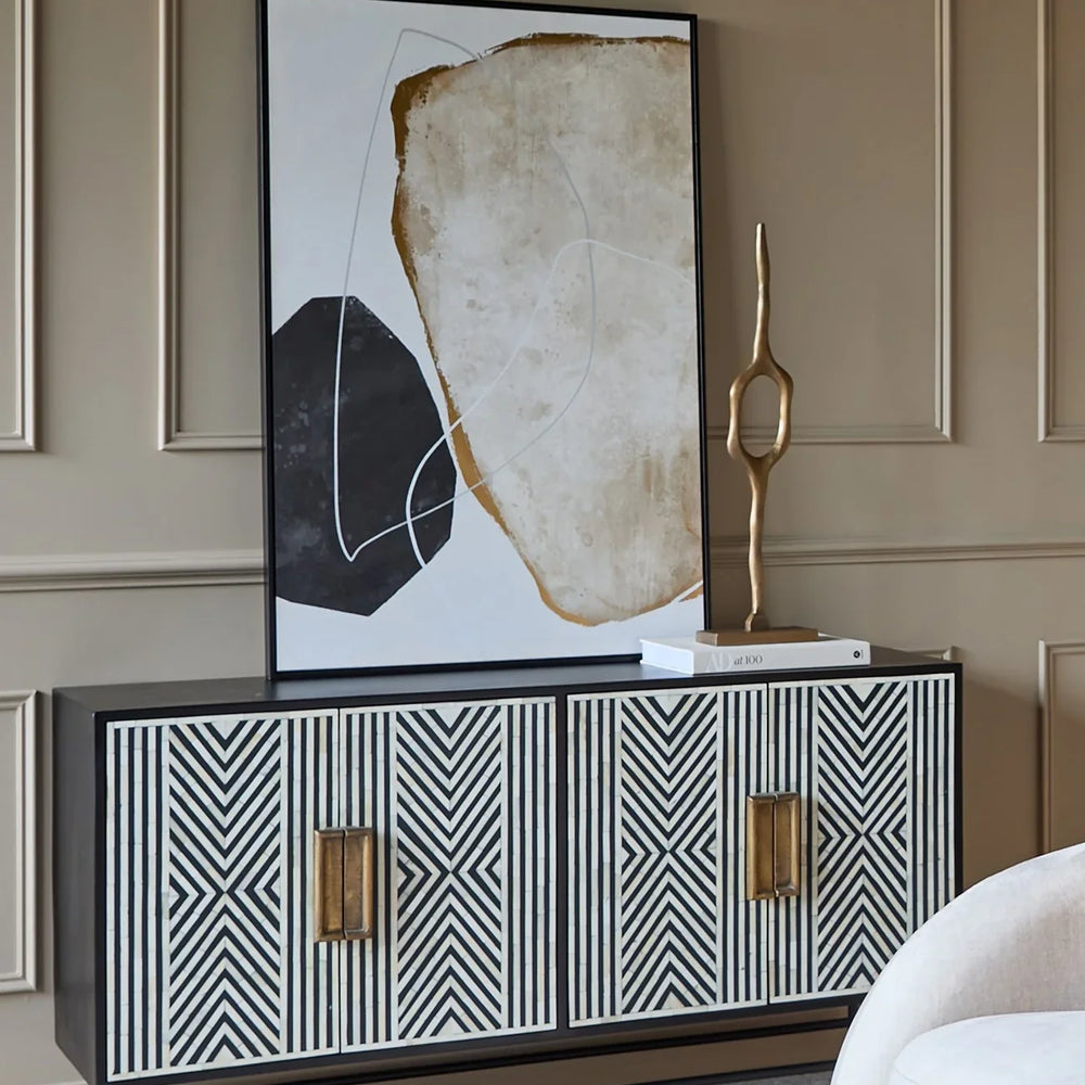 Black and white geometric cabinet in elegant living room with abstract art.