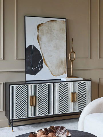Black and white geometric cabinet in elegant living room with abstract art.