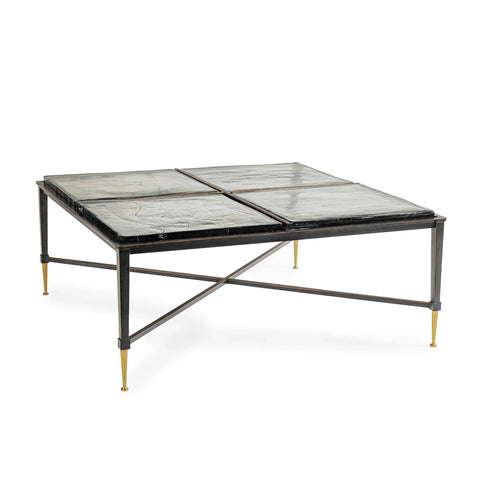 Black metal coffee table with glass top and gold-tipped legs.
