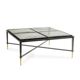 Black metal coffee table with glass top and gold-tipped legs.