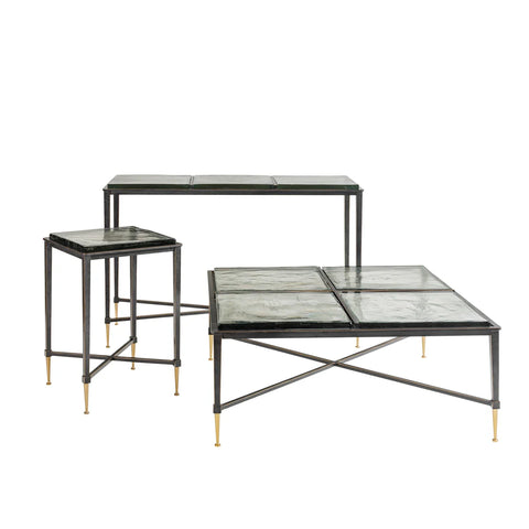 Set of three glass tables with black frames and gold-tipped legs.