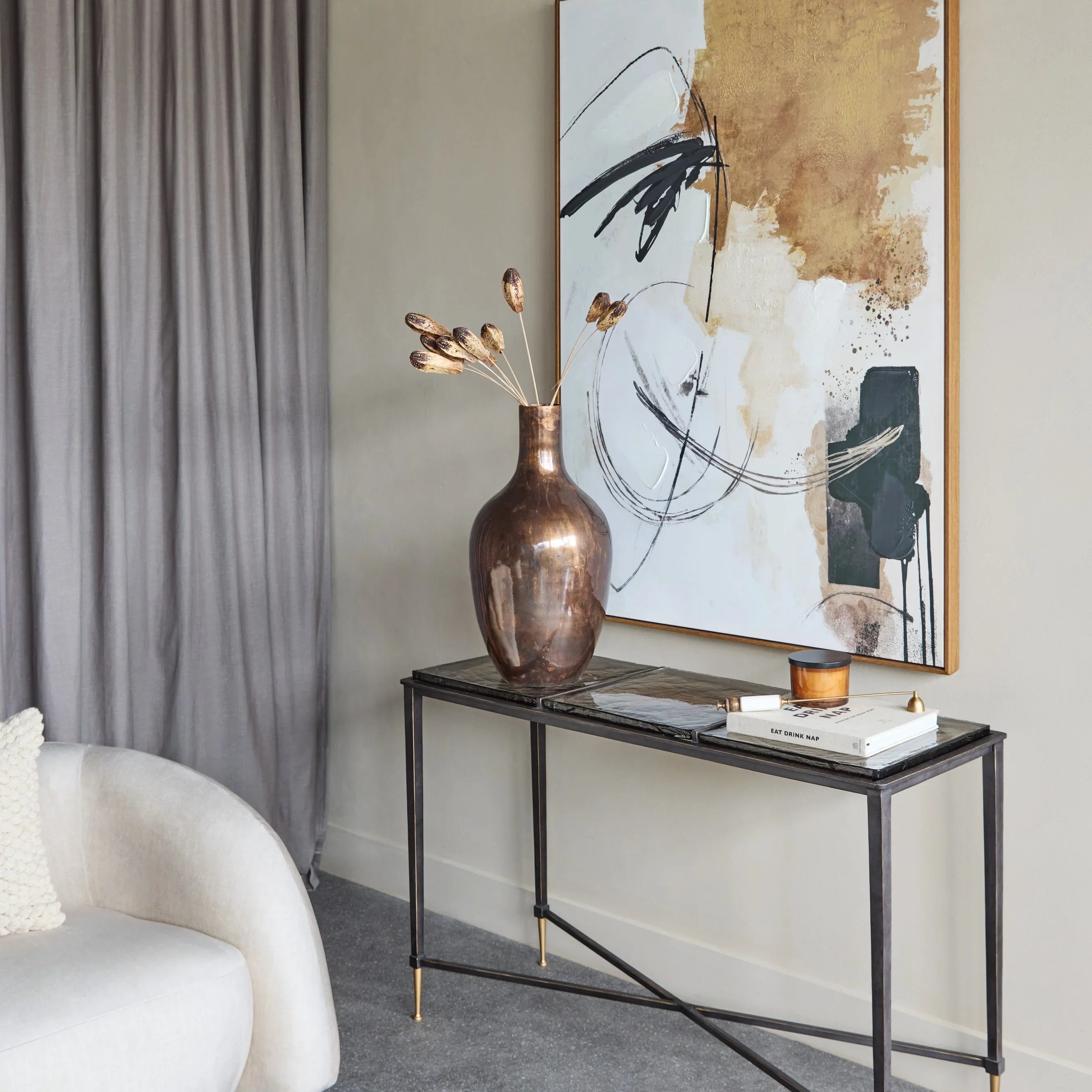 Glass console table with metal frame in modern living room setting.