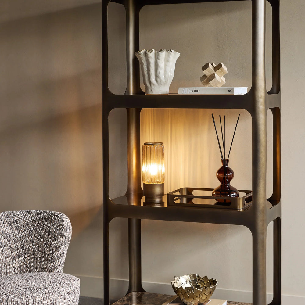 Smoked bronze shelving with decorative items in a cozy living room setting.