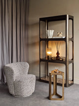 Cozy room with bronze shelving unit, textured chair, and marble accents.