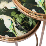 Close-up of round tray tables with tropical bird and leaf design.