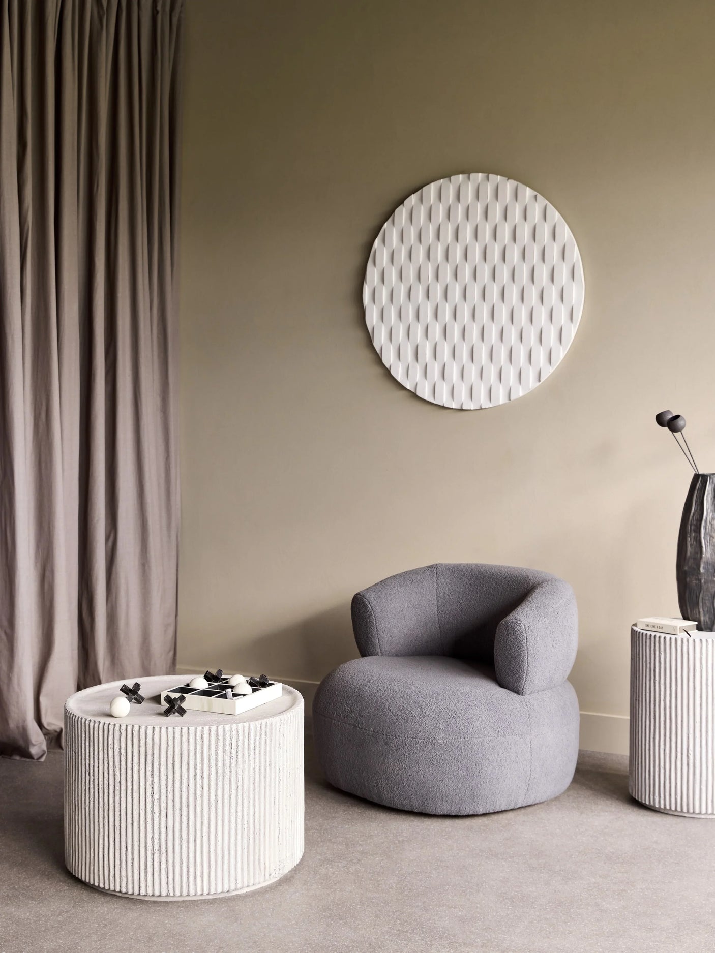 Cream round coffee table with ribbed texture in a cozy living room.