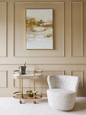 Aged gold drinks trolley beside a textured armchair in an elegant room.