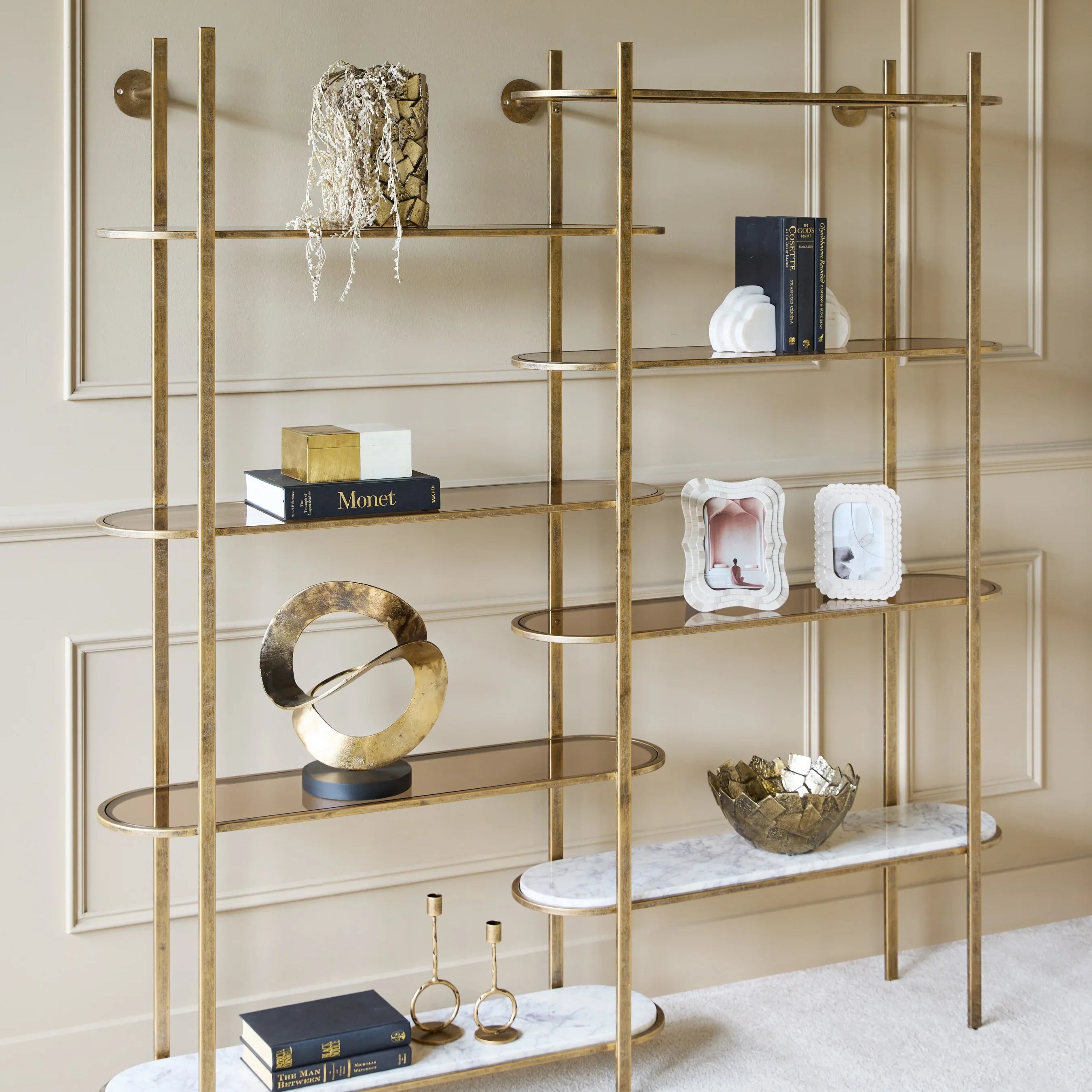 Aged gold shelving unit with decorative items in an elegant living room.
