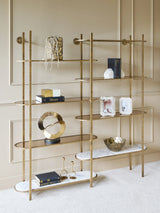 Aged gold shelving unit with decorative items in an elegant living room.