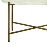 White inlay table with brass legs and crossbar detail.