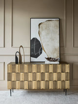 Brass sideboard with textured front, styled with abstract art and decor.
