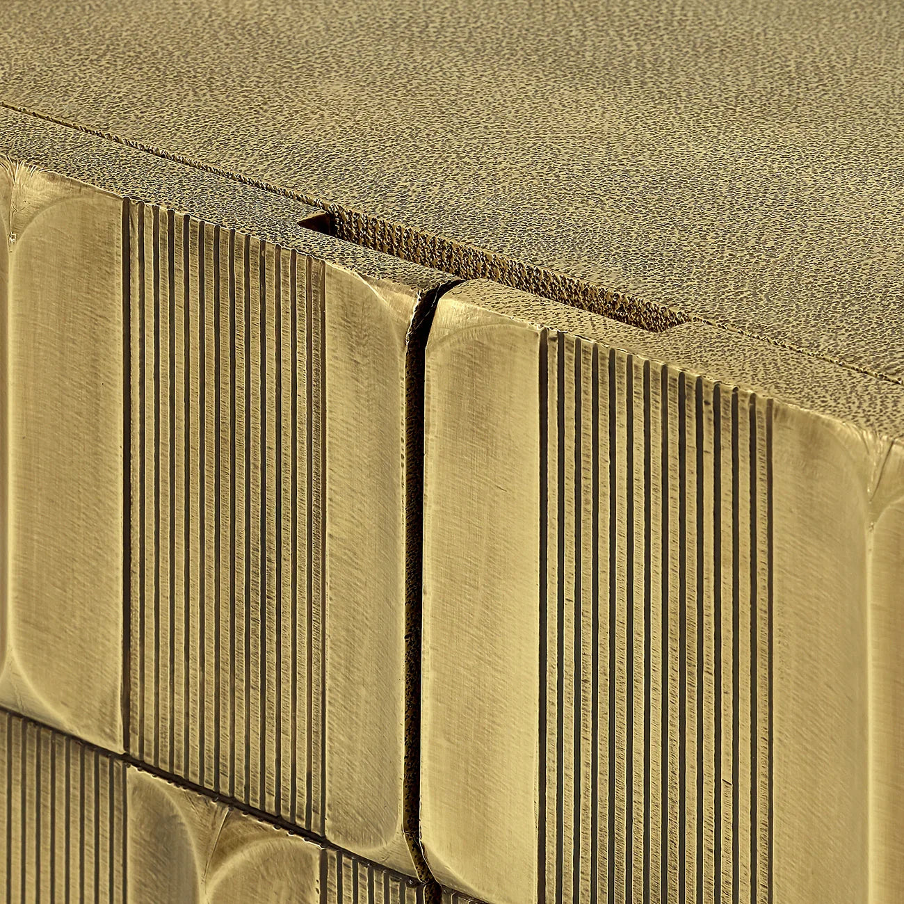 Brass cabinet detail with textured vertical lines and smooth edges.
