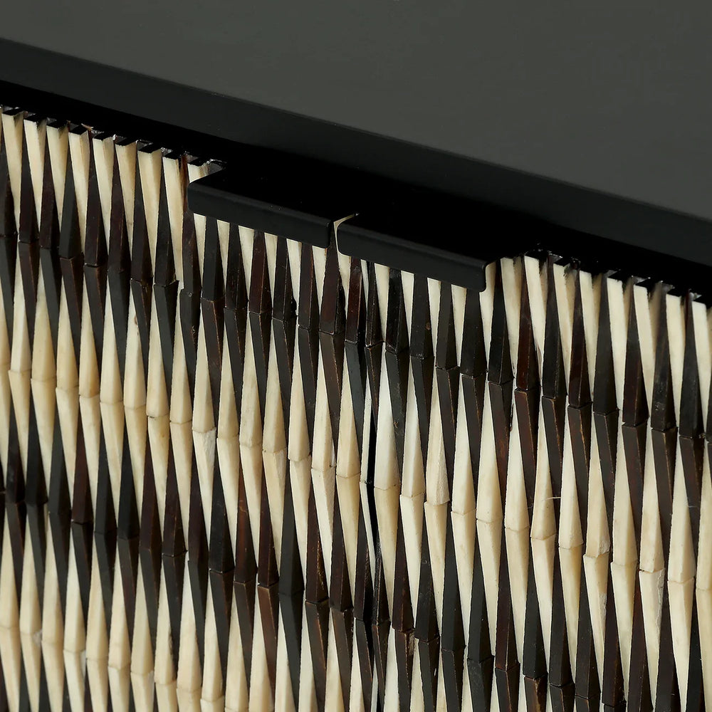 Black and ivory sideboard detail with geometric inlay pattern.