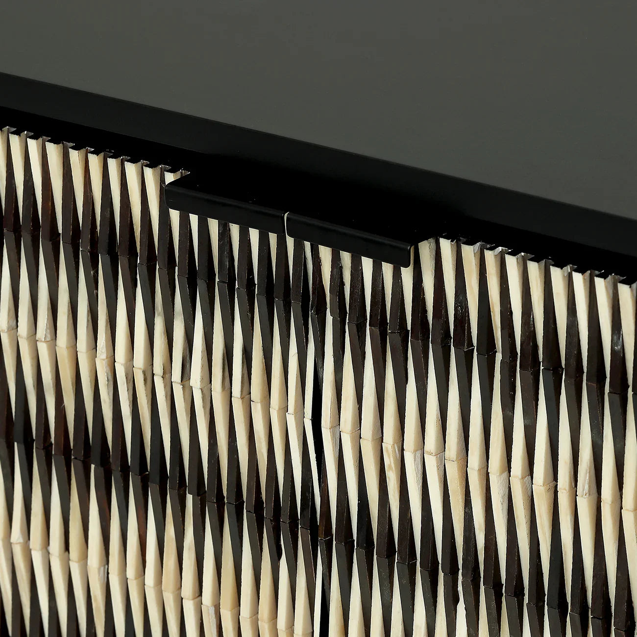Black and cream geometric pattern on cabinet door detail.