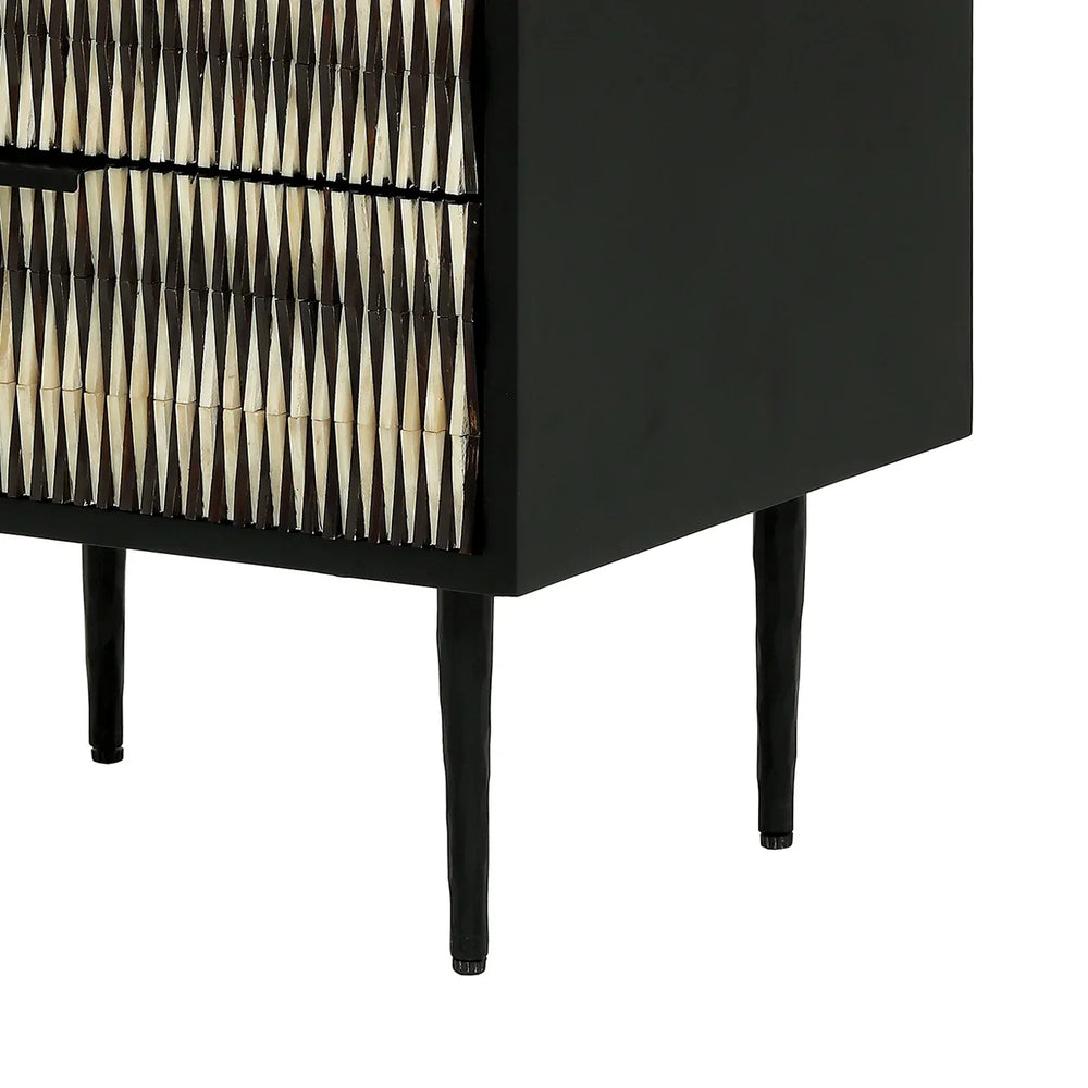 Black bedside table with geometric bone inlay pattern and slender legs.
