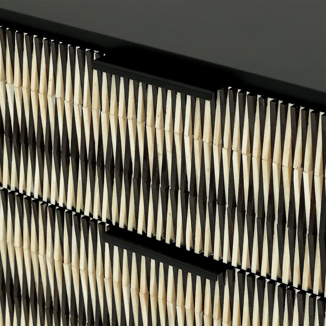 Black and ivory geometric pattern on chest drawer surface.