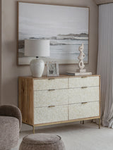 Cream inlay dresser in a serene living room with coastal artwork and decor.