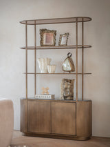 Gold shelving unit with decorative items in a modern living room setting.