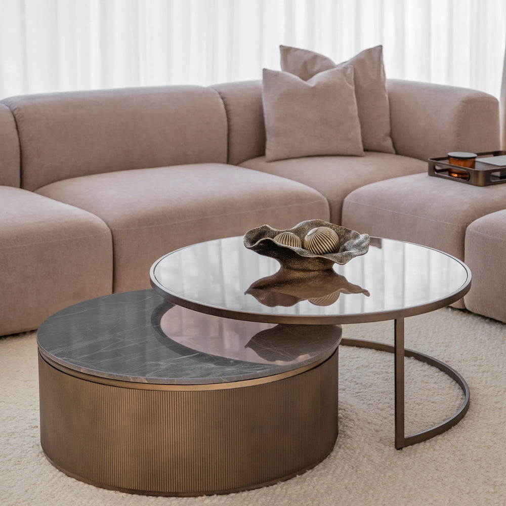 Gold nesting tables with glass tops in a cozy living room setting.