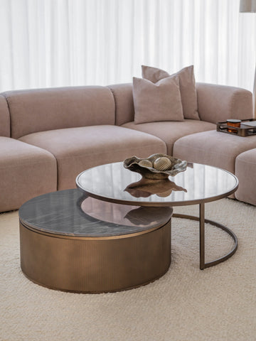 Gold nesting tables with glass tops in a cozy living room setting.