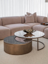 Gold nesting tables with glass tops in a cozy living room setting.