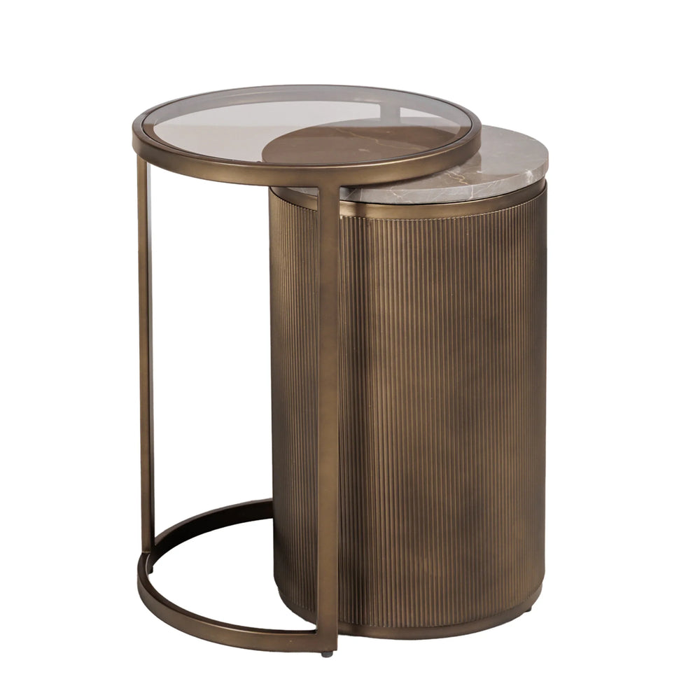Gold nesting side tables with ribbed cylindrical base and glass top.