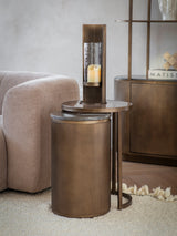 Bronze nesting tables in a cozy living room with a candle and plush sofa.