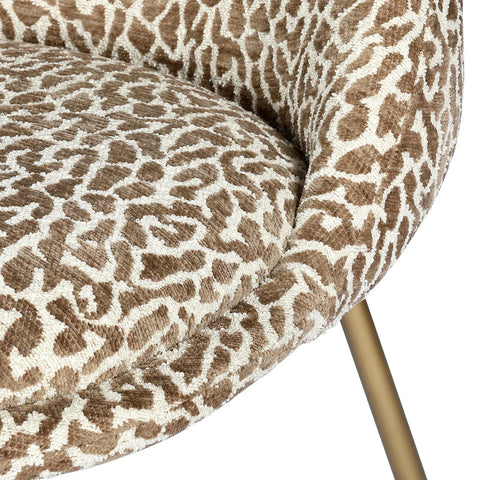 Brown and cream patterned upholstery with gold leg detail.