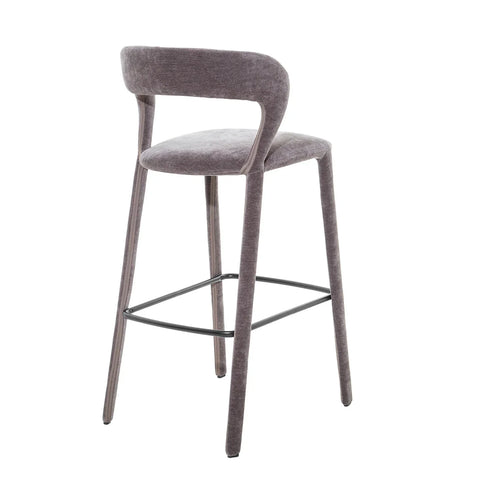 Grey upholstered bar stool with curved backrest and sleek metal footrest.