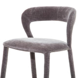 Grey upholstered bar stool with curved backrest and soft texture.