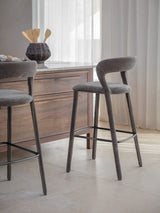 Grey upholstered bar stool beside wooden kitchen island.