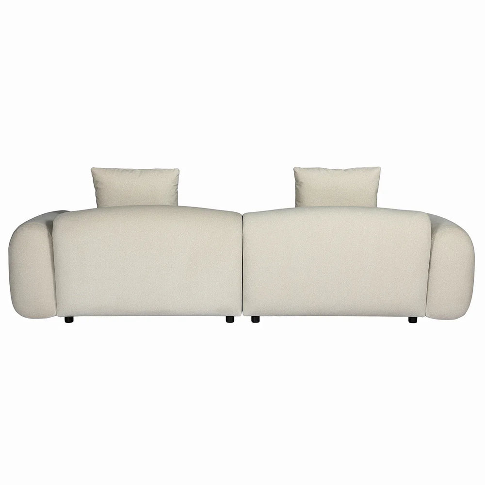 Back view of beige velvet sofa with plush cushions and rounded arms.