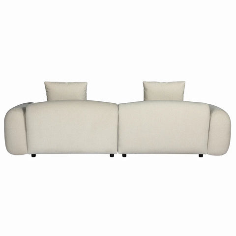 Back view of beige velvet sofa with plush cushions and rounded arms.