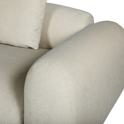 Warm stone velvet sofa arm with plush cushion detail.