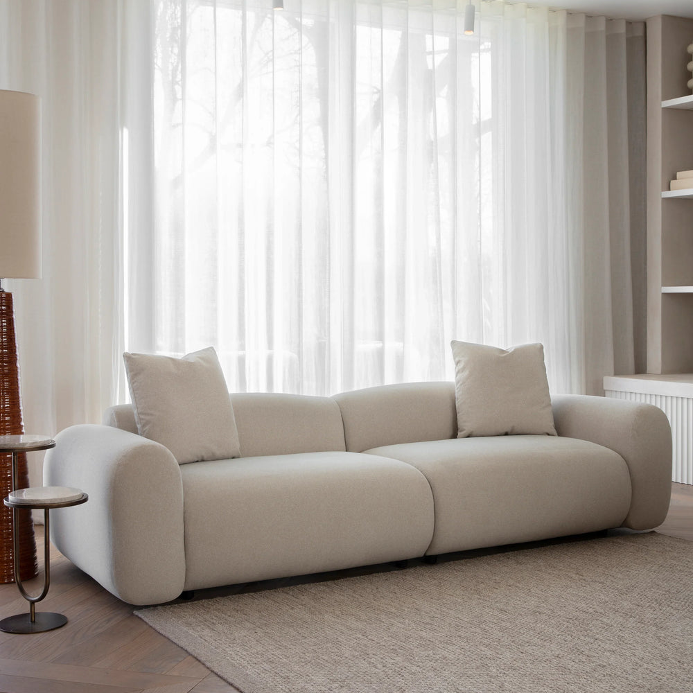 Warm stone velvet sofa in bright living room with sheer curtains