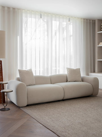 Warm stone velvet sofa in bright living room with sheer curtains